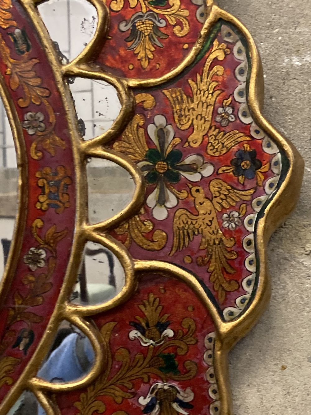 An Indian oval painted wall mirror, width 63cm, height 69cm